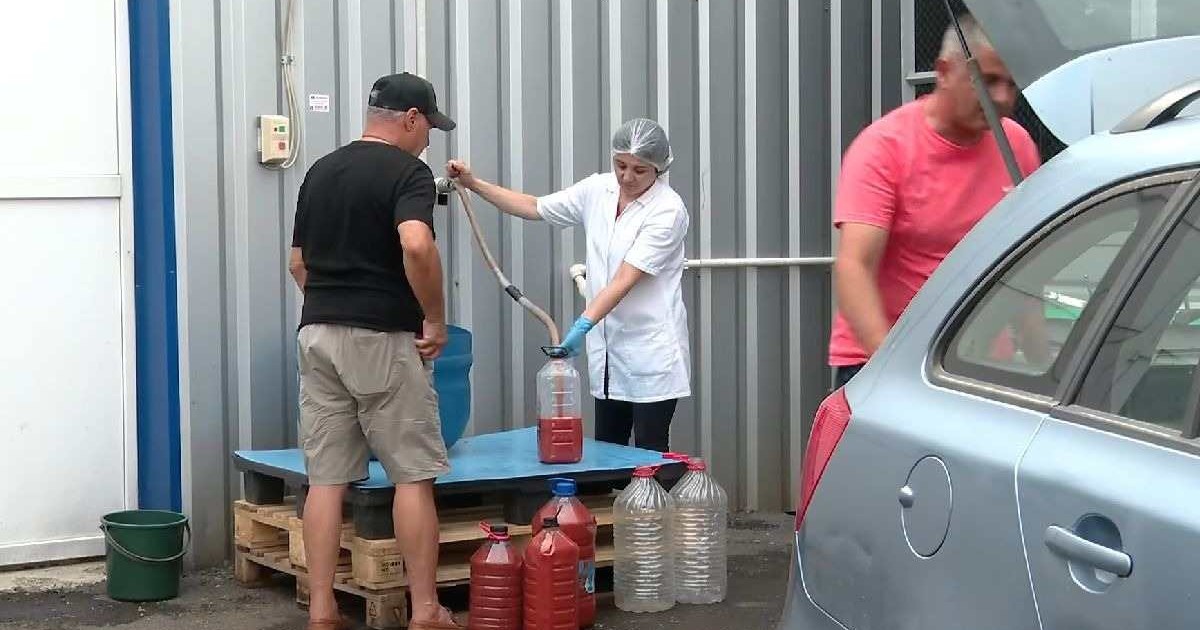O persoană achiziționează suc de roșii ,cu bidonul, direct de la poarta fabricii