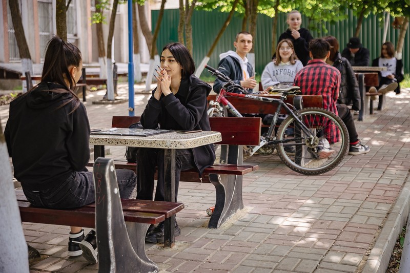 Adolescenții găgăuzi stau după-amiaza la povești la umbra Casei de Cultură din Comrat