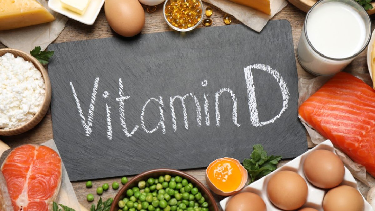 In mijloc pe o tabla neagra scire Vitamina D cu alb pe margine alimente care contin vitamina D peste, oua, lapte, somon