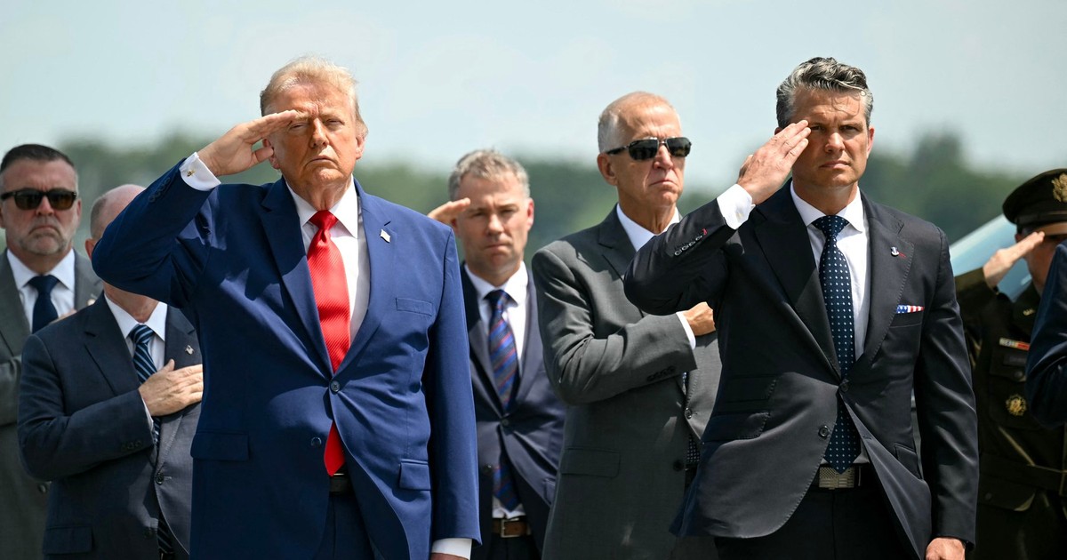Donald Trump (stânga, în prim-plan) și secretarul apărării Pete Hegseth (dreapta, în prim-plan) salută trupele în momentul repatrierii unor soldați americani uciși în războiul cu Iran Foto: Profimedia