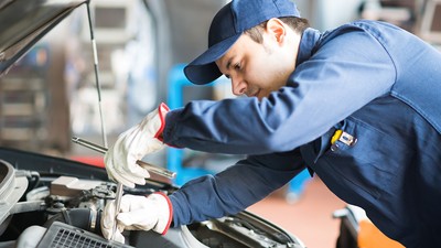 Auto mechanic working on a car in his garage