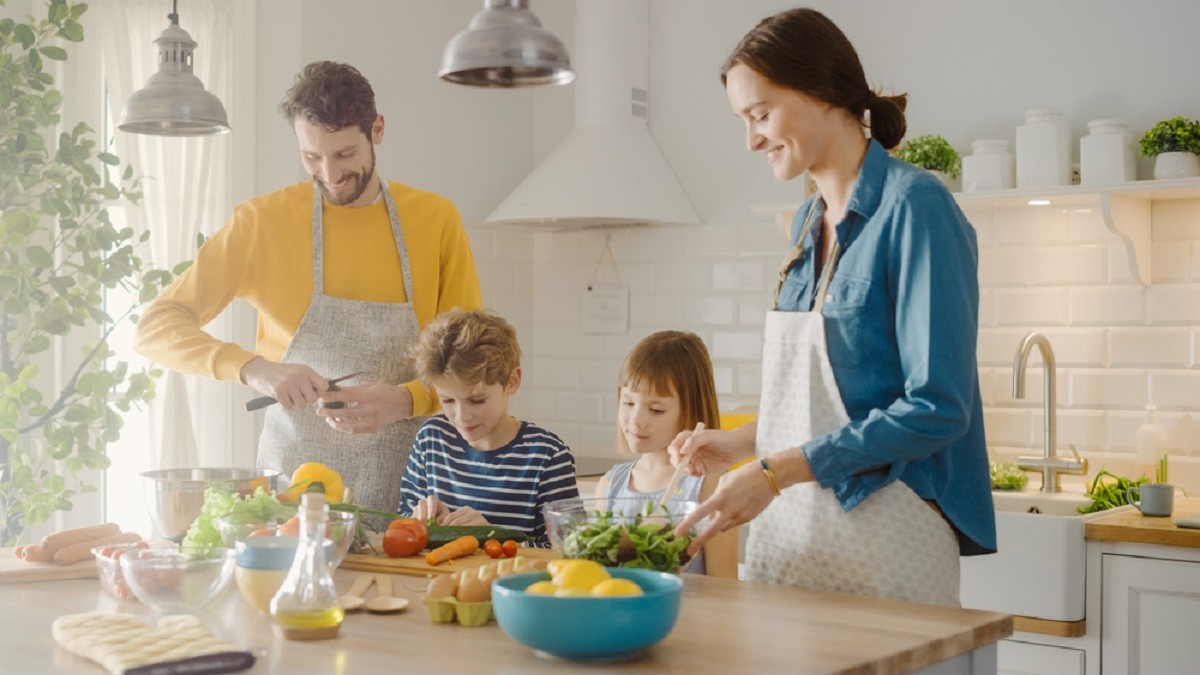 Cum să hrănești o familie de 4 persoane cu 50 de lei pe zi - Doi părinți cu cei doi copii ai lor pregătesc cina Sursa foto: Shutterstock