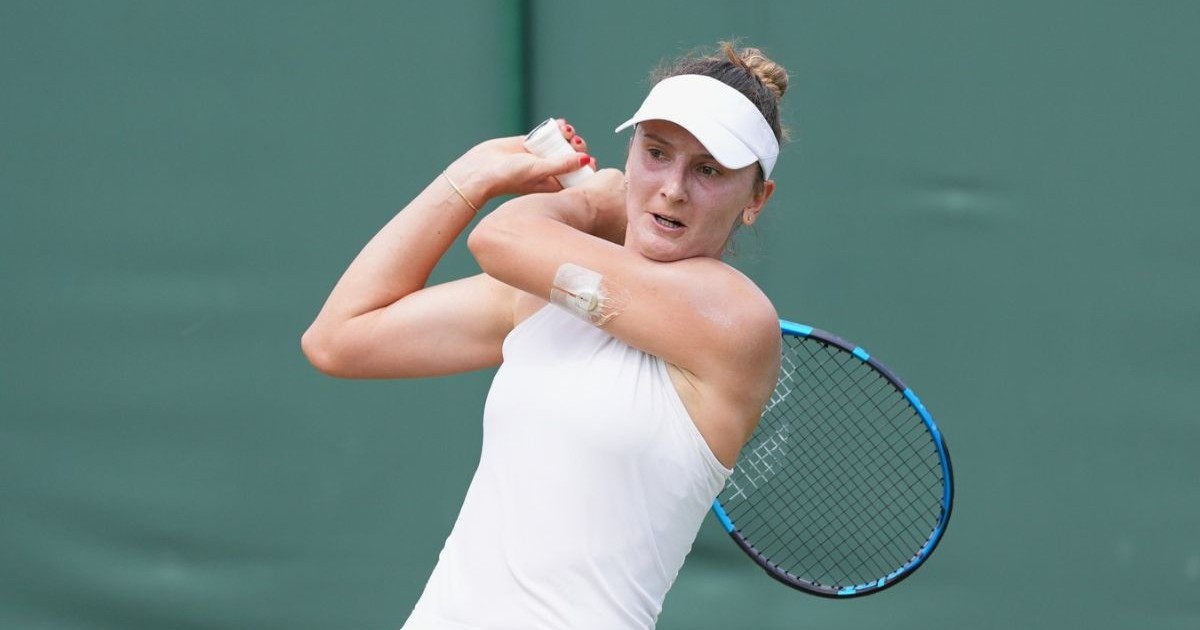 Irina Begu, îmbrăcată îtntr-un compleu de tenis alb, cu o banderolă cu cozoroc albă, ținând racheta de tenis peste umăr, în timpul meciului de marți, 1 iunie, din timpul turneului internațional de tenis Wimbledon 2025
