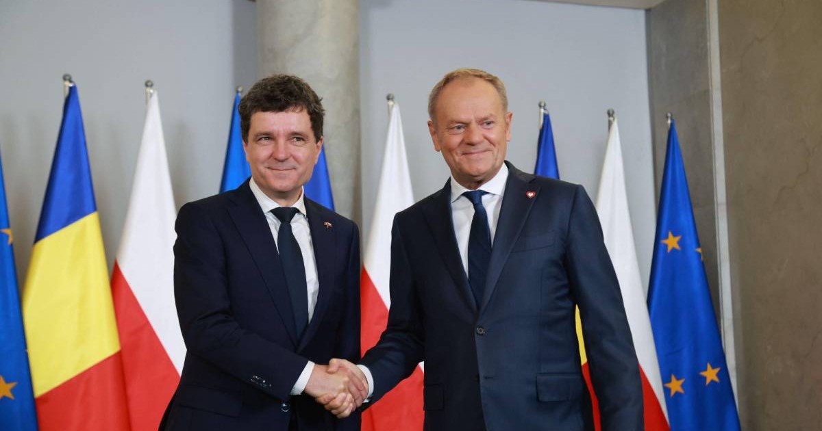 Nicușor Dan (stânga) și Donald Tusk (dreapta) surprinși în timp ce dau mâna.