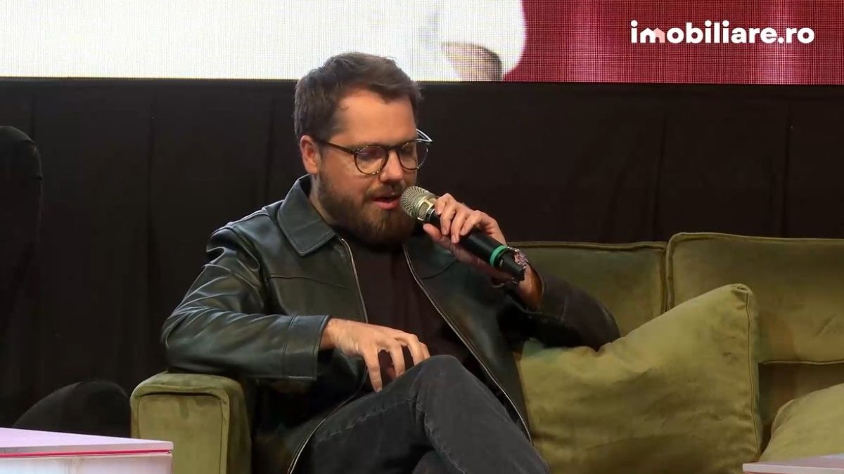 Gaspar Gyorgy, îmbrăcat într-o geacă de piele neagră, cu blugi negri, pe canapea, la conferința Imobiliare.ro HUB Național 2025