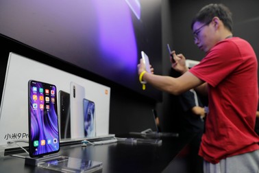 epa07865525 A visitor takes a photo of a Xiaomi Mi 9 Pro 5G smartphone after the Xiaomi new 5G smartphone product launch ceremony in Beijing, China, 24 September 2019. Xiaomi releases its new mobile phone products 'Mi 9 Pro 5G' and 'Xiaomi MIX Alpha' on 24 September 2019. EPA-EFE/WU HONG