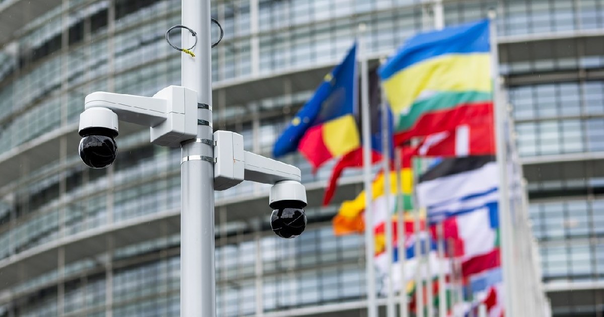 29 mai 2024, Franța, Straßburg: Camere de supraveghere sunt montate pe un stâlp, în timp ce drapelele Uniunii Europene, ale statelor sale membre și ale Ucrainei pot fi văzute în fundal în fața clădirii Parlamentului European