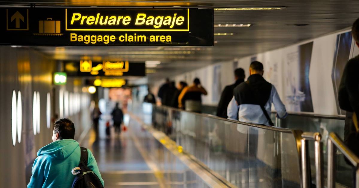 Mai mulți pasageri pe culoarul Aeroportului Otopeni care leagă zone de control pașapoarte de zona pentru preluarea bagajelor