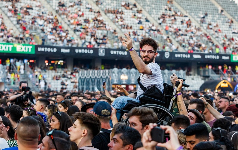 Fotografia zilei la UNTOLD. Tânăr în scaun cu rotile, ridicat deasupra mulțimii, în timpul concertului INNEI