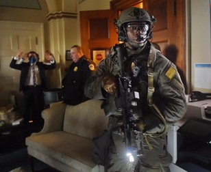 Doi congresmani țin mâinile ridicate, în timp ce o echipă SWAT verifică oamenii aflați în clădirea Capitoliului, miercuri, 6 ianuarie. Foto: Profimedia