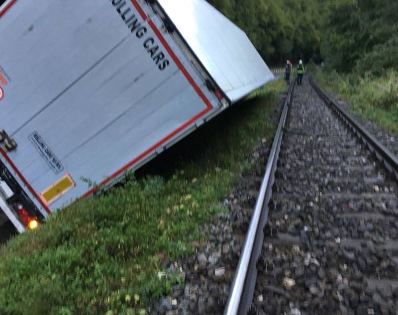 UPDATE: Călătorii din trenul Cluj-Oradea, blocat din cauza unui camion răsturnat pe calea ferată, transbordați