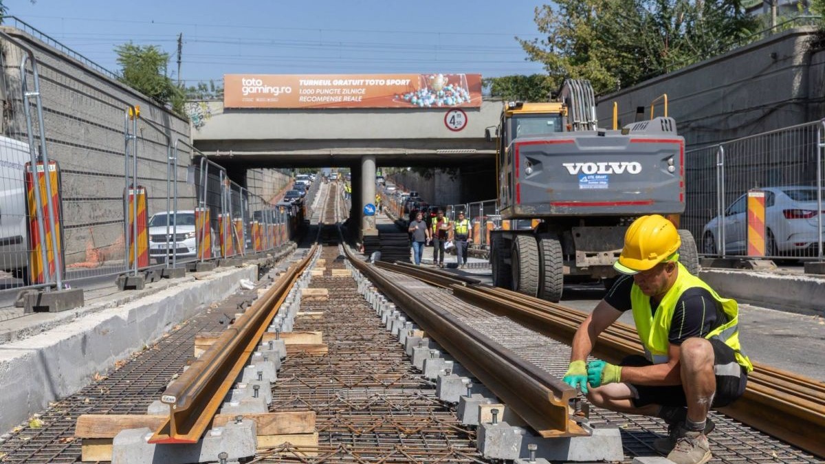 Un muncitor lucrează la montarea șinelor de cale ferată lângă Podul Constanța din București, 15 august 2026