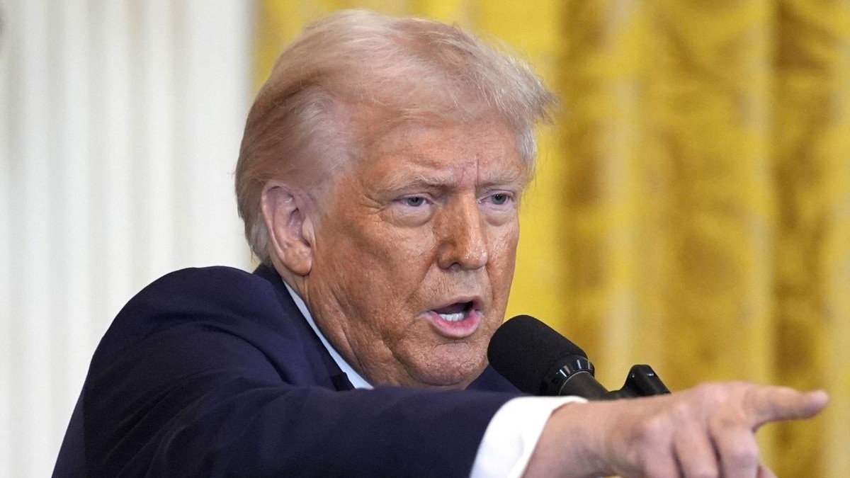 Donald Trump, îmbrăcat într-un costum negru, arată acuzator cu degetul în timpul unei conferințe de presă, februarie 2025