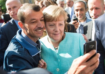 Angela Merkel, alături de un refugiat, la un centru de primire din Berlin | FOTO: EPA