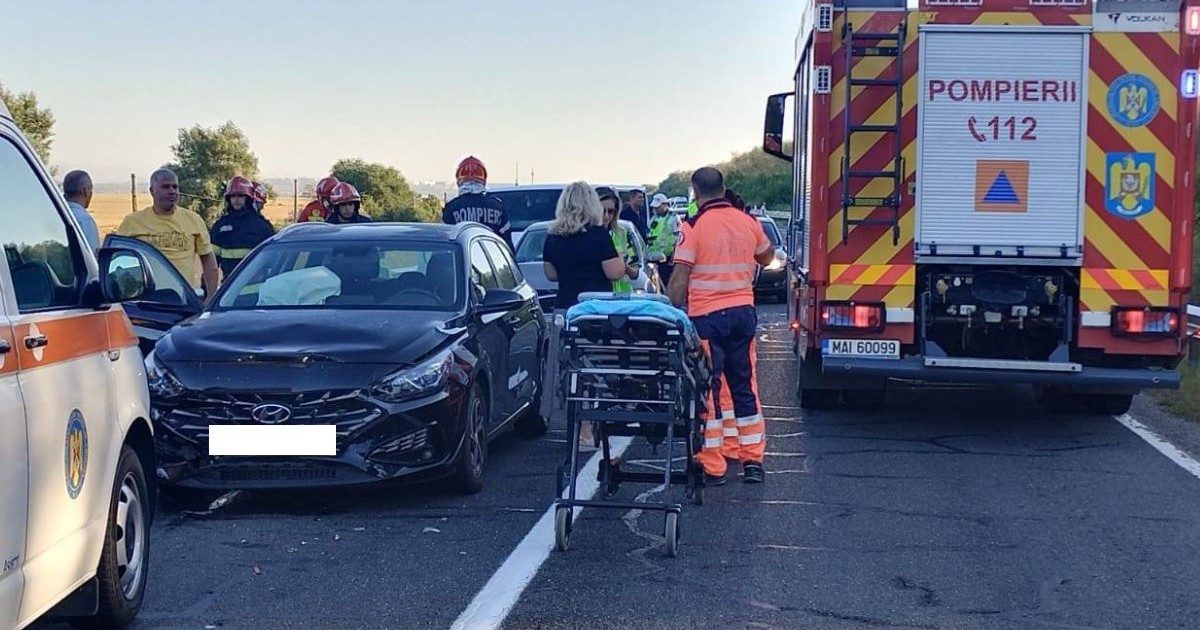 mașină Hyundai lovită, staționată paralel unei autospeciale de pompieri. în mijocul imaginii este o targă
