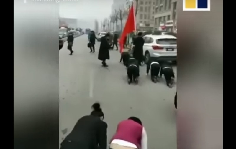 VIDEO | Angajații unei companii au fost forțați să se târască în genunchi pe străzi, fiindcă n-au îndeplinit norma de profit