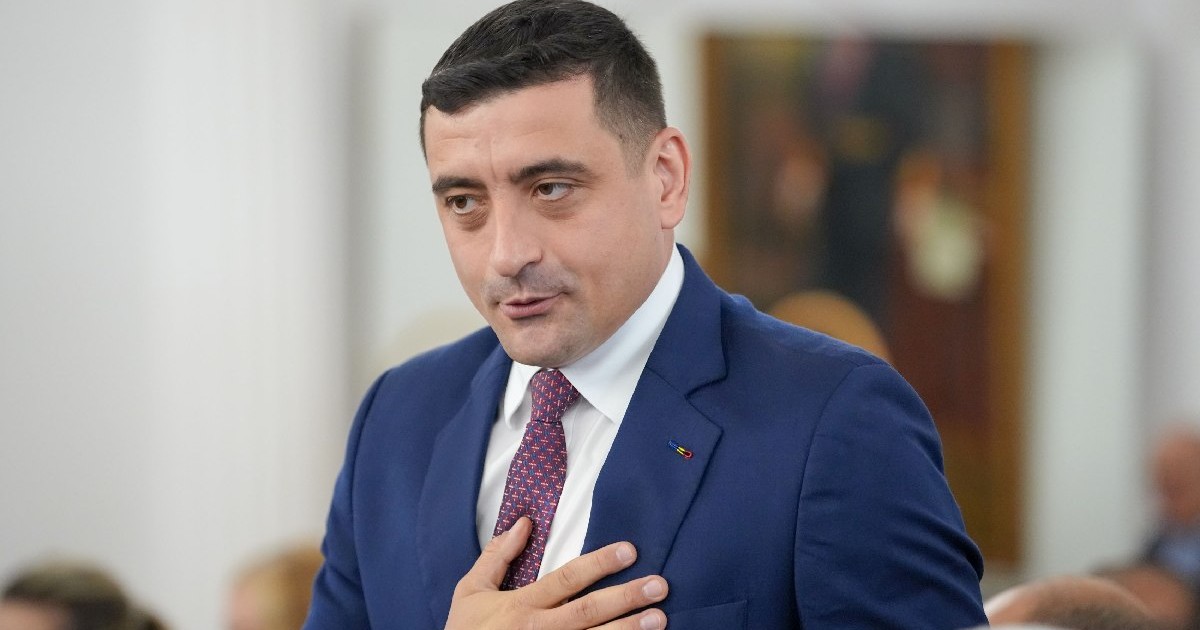george Simion, îmbrăcat în costum bleumarin, camasa alba si cravata albastru cu rosu, tine mana pe piept