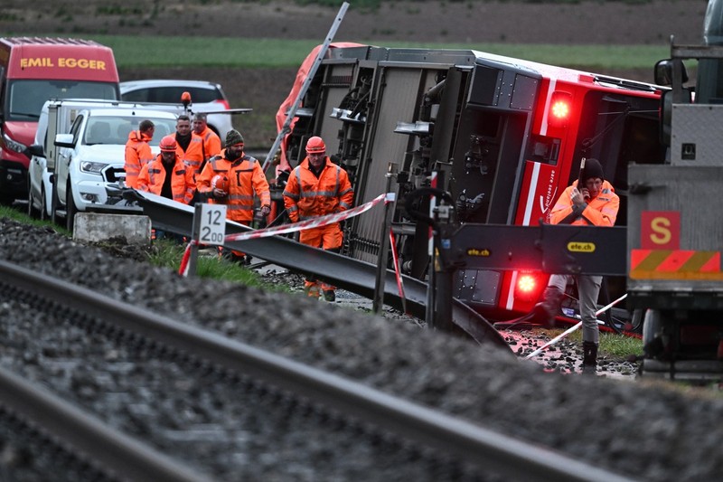 Train staff work on the site of a train derailment near lakeside town of Luscherz, northwest of the capital Bernin on March 31, 2023. Several people have been hurt in two separate train derailments that happened in quick succession in bad weather in northwestern Switzerland, police said The incidents took place about 30 kilometres apart, north of the Swiss capital Bern.,Image: 766414672, License: Rights-managed, Restrictions: , Model Release: no