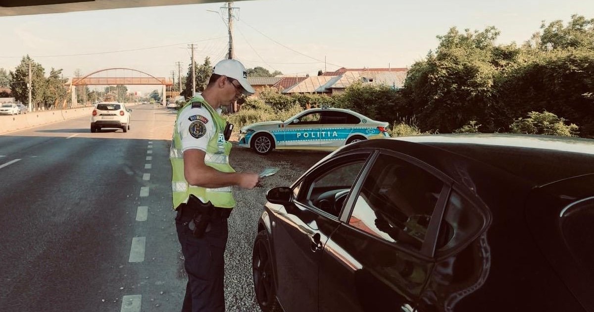 Un polițist a oprit pe dreapta un șofer și îi verifică actele
