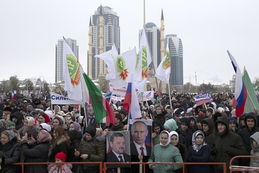 Oamenii țin portrete ale lui Akhmad Kadîrov și Vladimir Putin în timpul unei sărbători la Groznîi, Republica Cecenă, Rusia, care marchează Ziua Unității Naționale a Rusiei | Foto: Profimedia