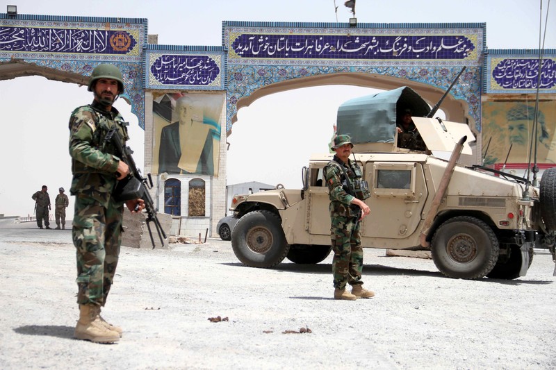 Soldații ai Armatei Naționale Afgane (ANA) stau de pază la un punct de control al drumului în Herat. Foto EPA