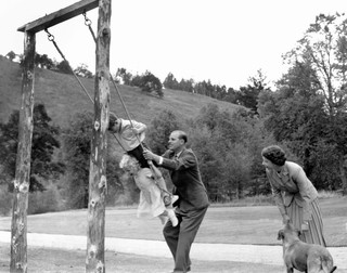 14 septembrie 1955: prințul Philip îi dă în leagăn pe copiii săi - prințul Charles și prințesa Anne, alături de regina Elisabeta a II-a
