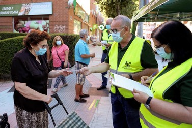 Voluntarii unei asociații oferind măști gratuite pe străzile Madridului | Foto: EPA