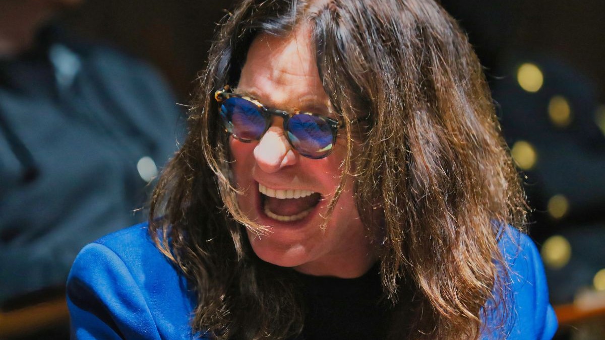 Cadru str\ns cu Ozzy Osbourne, cu parul desfacut si ochelari de soare, in sacou albastru electric. Los Angeles, 2016