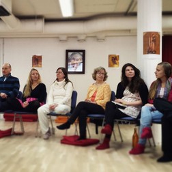 Cursanți la Natha Yoga School într-o sală în care este și fotografia lui Gregorian Bivolaru pe perete