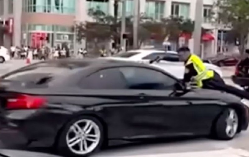 Momentul în care un polițist împușcă un șofer prin parbriz, după ce a fost luat pe capota mașinii, la Miami | VIDEO