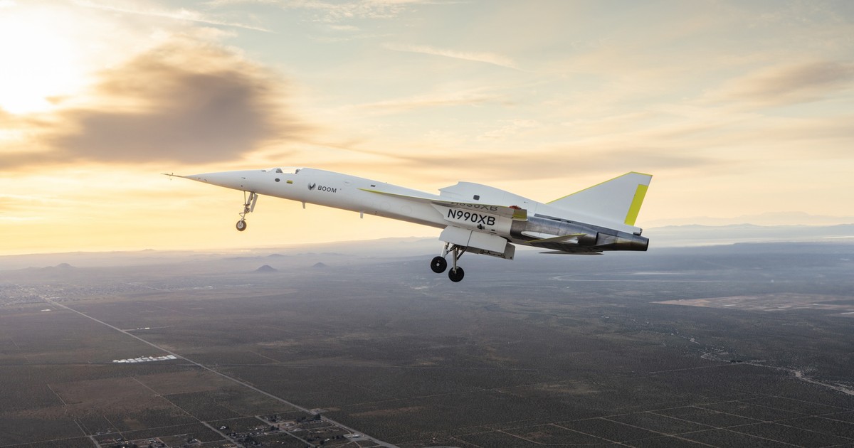 Avionul supersonic de test, XB-1, în timpul zbourlui, cu apusul soarelui pe fundal.