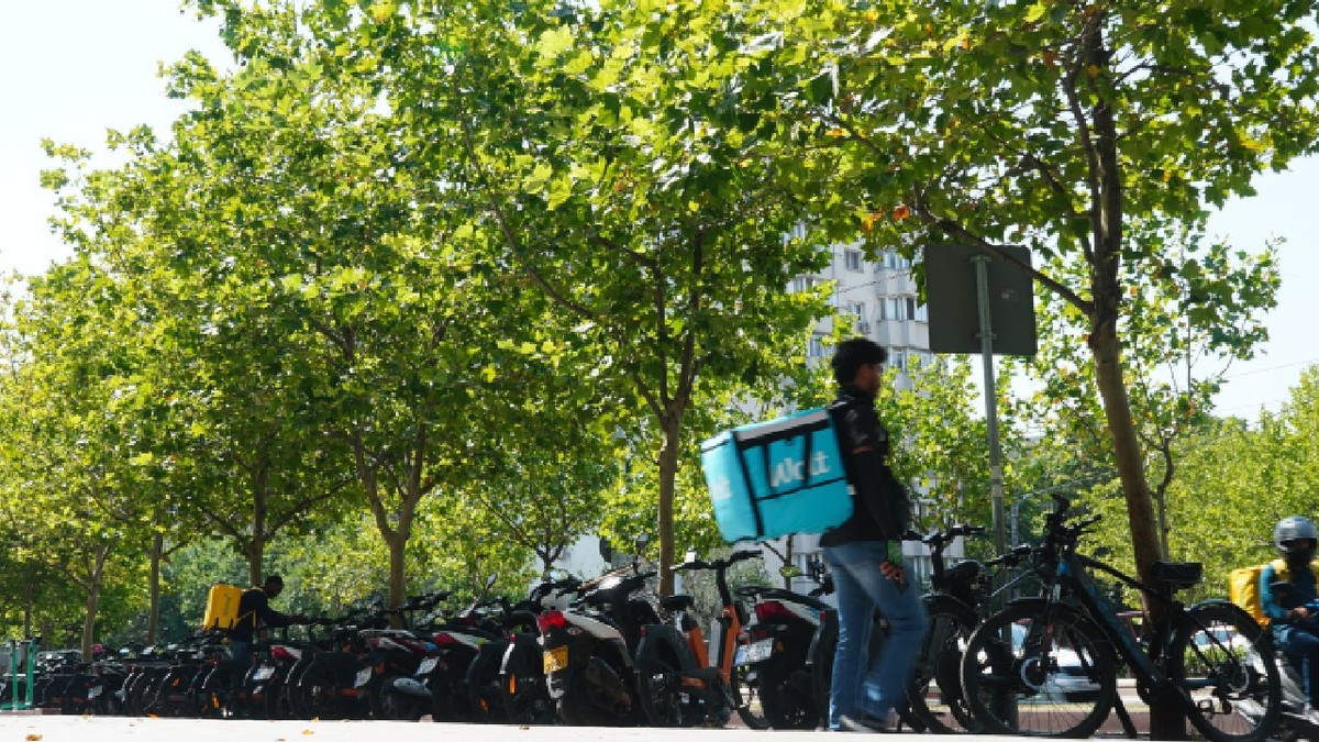 București, România - 26 iulie 2025: Parcare pentru biciclete și scutere ale angajaților din domeniul livrării de alimente, în principal imigranți, în fața Bucharest Vitan Mall