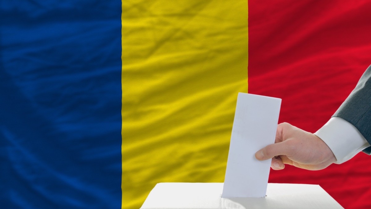 Imagine cu un bărbat care introduce un buletin de vot într-o urnă.