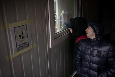 Costeluș și prietenul lui se uită pe geam să vadă ce se întâmplă în adăpost. Sunt nerăbdători să intre. Așteaptă de câteva ore.