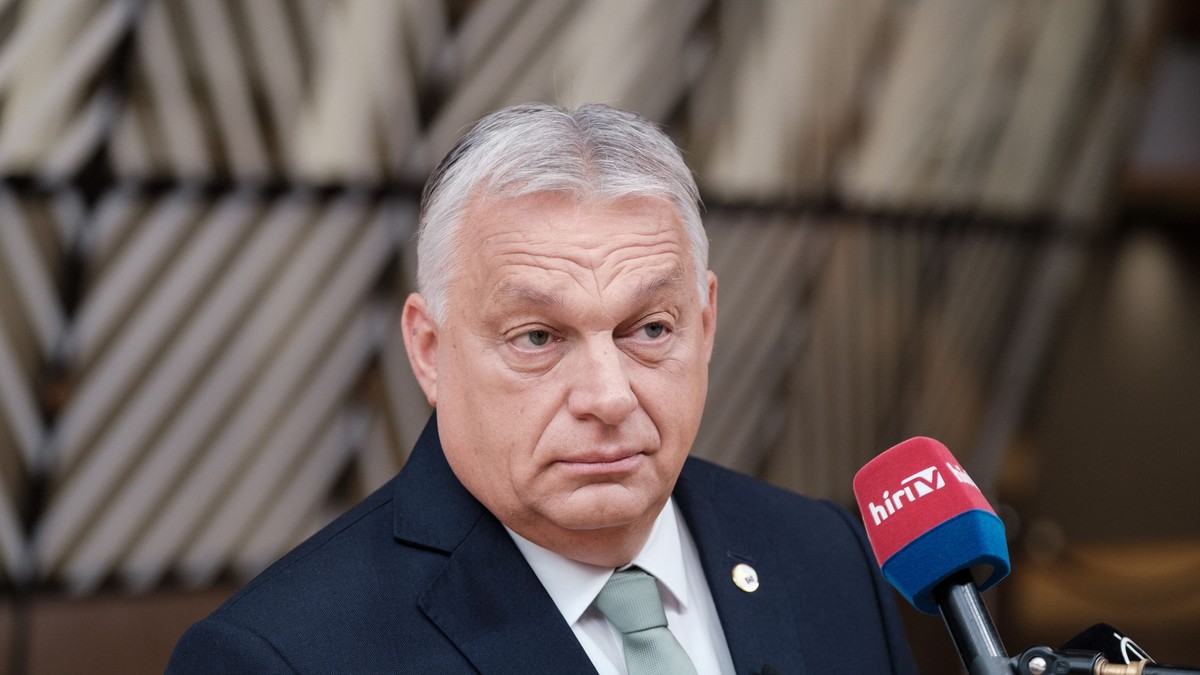Viktor Orban surprins având un microfon în față la Bruxelles în iunie 2025. Poartă un sacou negru, o cravată gri și o cămașă albă