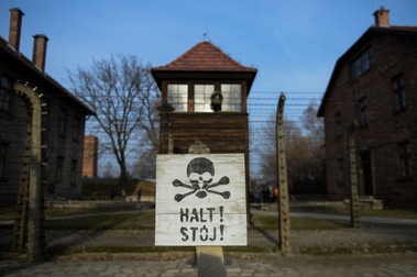 Mesaj de avertisment atârnat de gardul de sârmă ghimpată al fostului lagăr de concentrare de la Auschwitz | FOTO: HEPTA