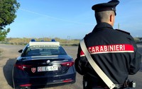 Un politist italian pe o autotradă, lângă o mașină de carabinieri, în timp ce controlează traficul