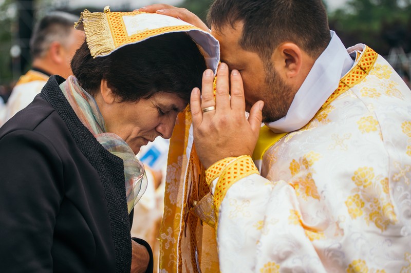 Un preot spovedește o femeie înainte de întâlnirea dintre enoriașii catolici și Sanctitatea Sa Papa Francisc pe Câmpia Libertății din Blaj.