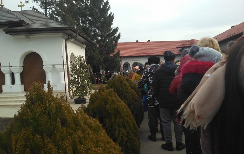 REPORTAJ/ Mii de pelerini la mănăstirea prahoveană Ghighiu au stat la cozi de zeci de metri pentru agheasmă/ FOTO