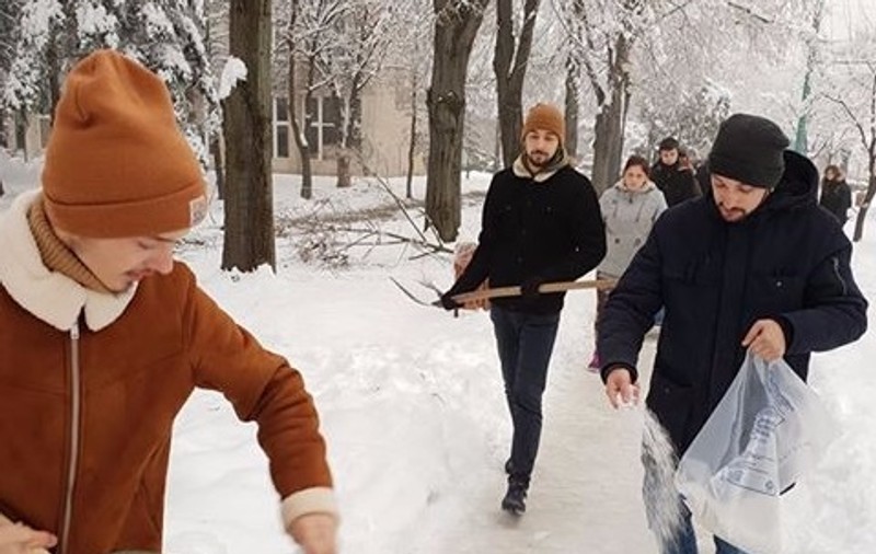 FOTO/ Studenții au ieșit să deszăpezească un trotuar de pe un bulevard din Timișoara pentru că s-au săturat să aștepte Primăria. Robu spune că s-a făcut "tot ce era omenește posibil"