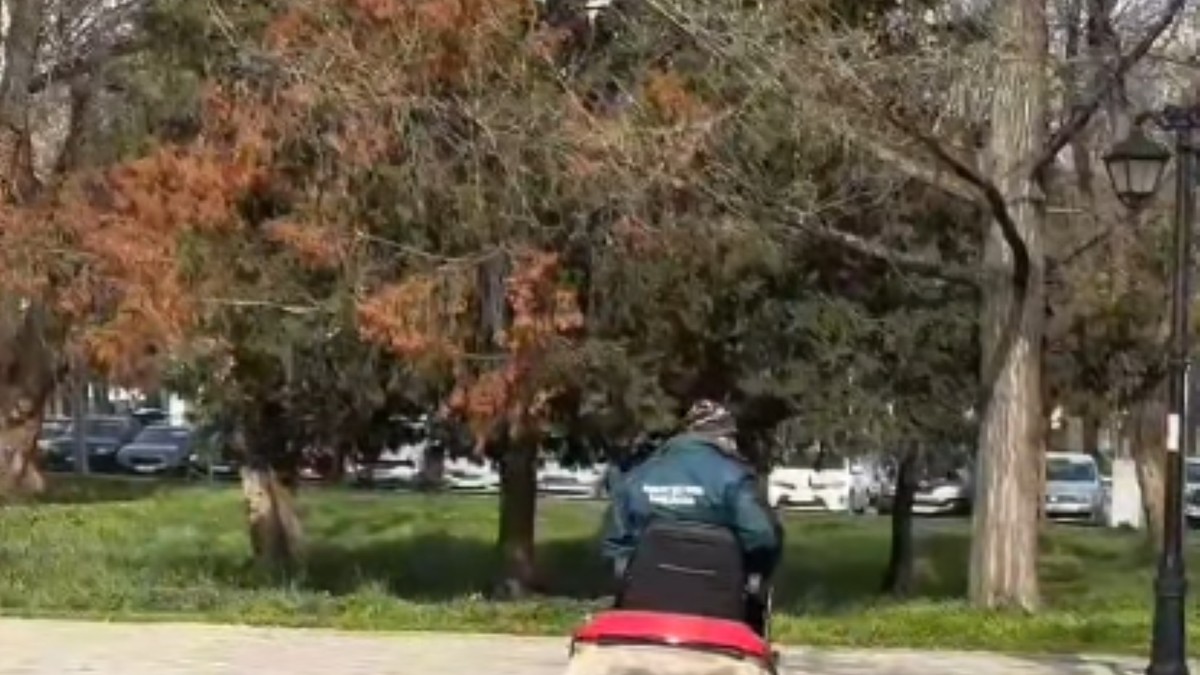 Persoană care tunde iarba cu ajutorul unui utilaj