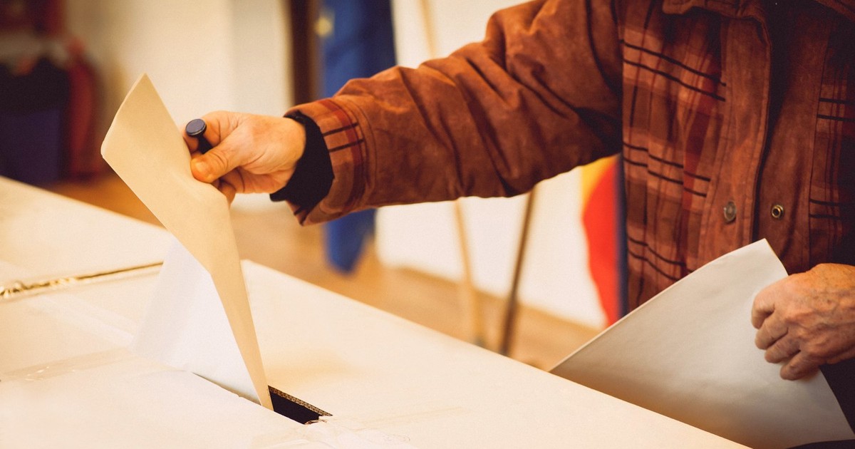 Alegător care introduce buletinul de vot în urmă