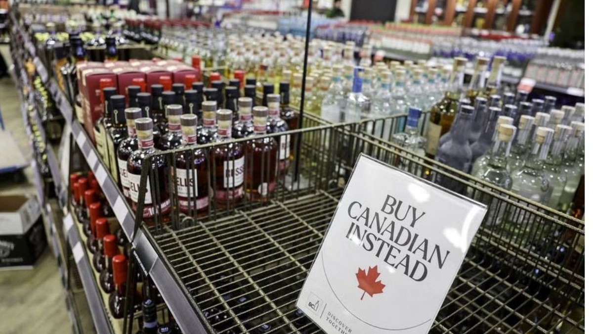 Raft cu sticle într-un magazin din Canada cu un indemn să fie cumpărate produse canadiene în locul celor americane.