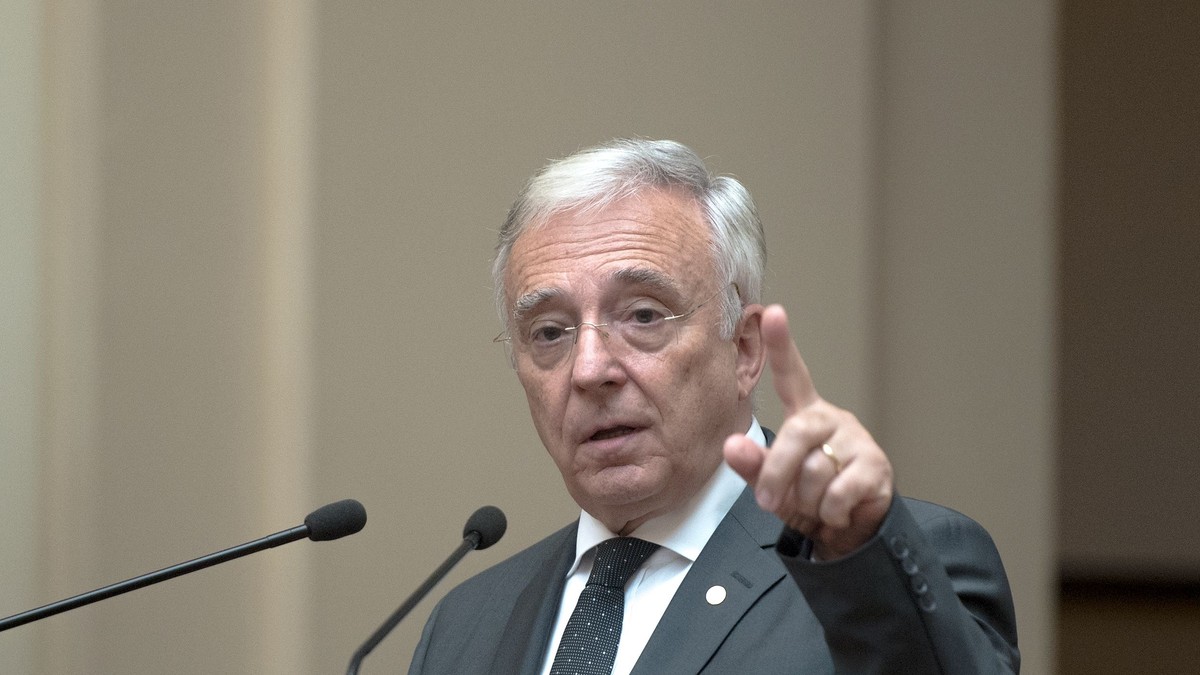 Isarescu: pandemia modelează economia globală. Investițiile verzi și digitalizarea, în centrul redresării economice. Isărescu la un microfon arătând cu degetul