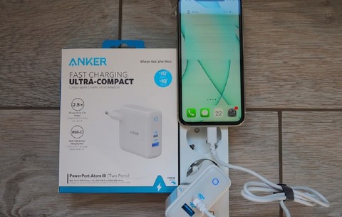 Imagine cu un încărcător Anker de telefon conectat la priză şi la un smartphone