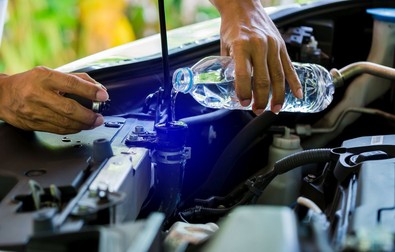 hands of Mechanic Check water in Car radiator and Add water to car radiator, Service and maintenance of cars or vehicles, selective focus.
