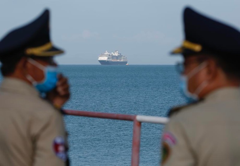 Polițiști cambodgieni poartă măști de protecție pe față în timp ce vasul MS Westerdam se apropie de portul Preah Sihanouk FOTO: EPA-EFE/KITH SEREY