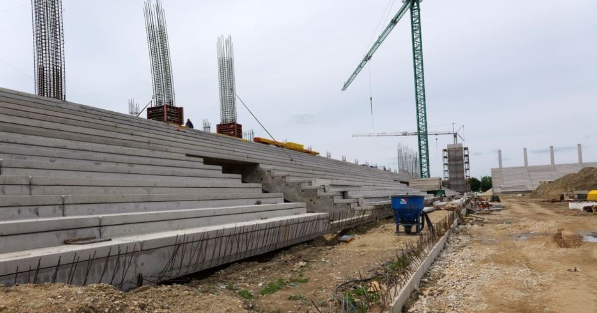 stadionul timisoarei este in constructie. in imagine se vad niste tribune de beton, mormane de nisip si o macara