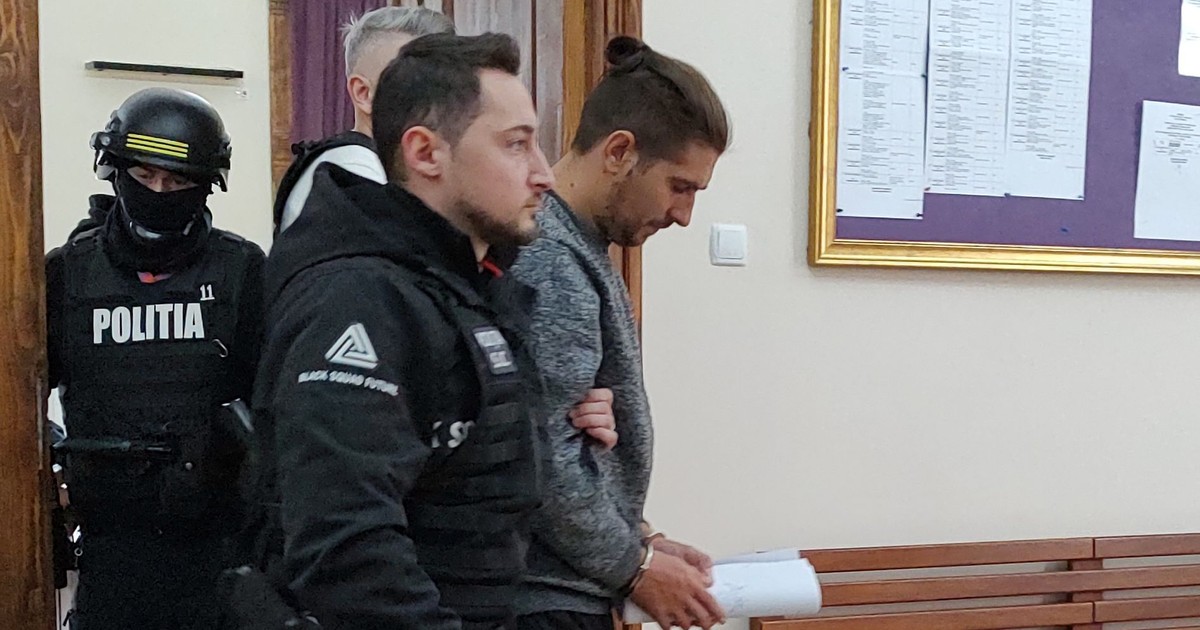 Un inculpat iese escortat de politisti din sala de judecata