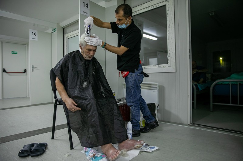 Petru este tuns de către Mario, unul dintre voluntari, după ce i-a tratat rănile de la picioare suferite în urma degerăturilor